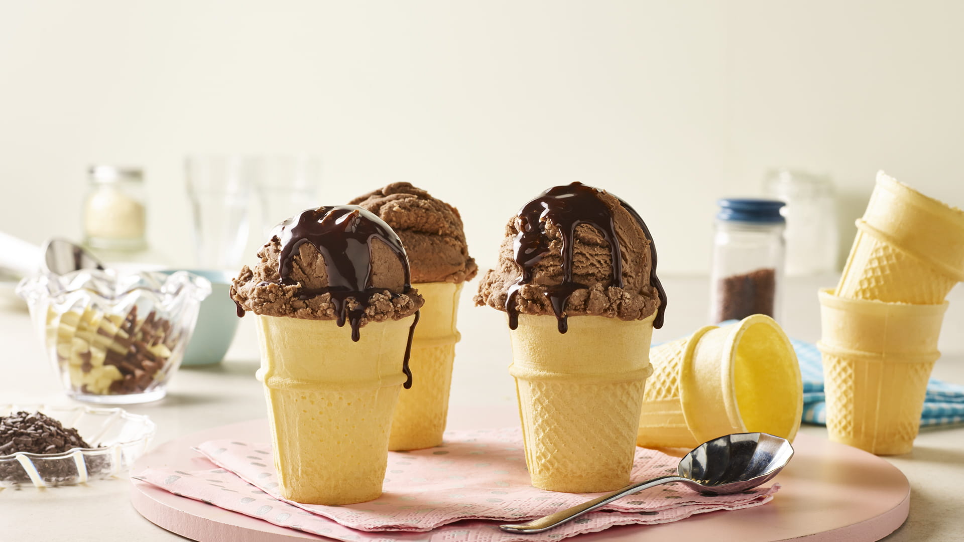 Wafer cones filled with chocolate ice cream and topped with chocolate sauce.