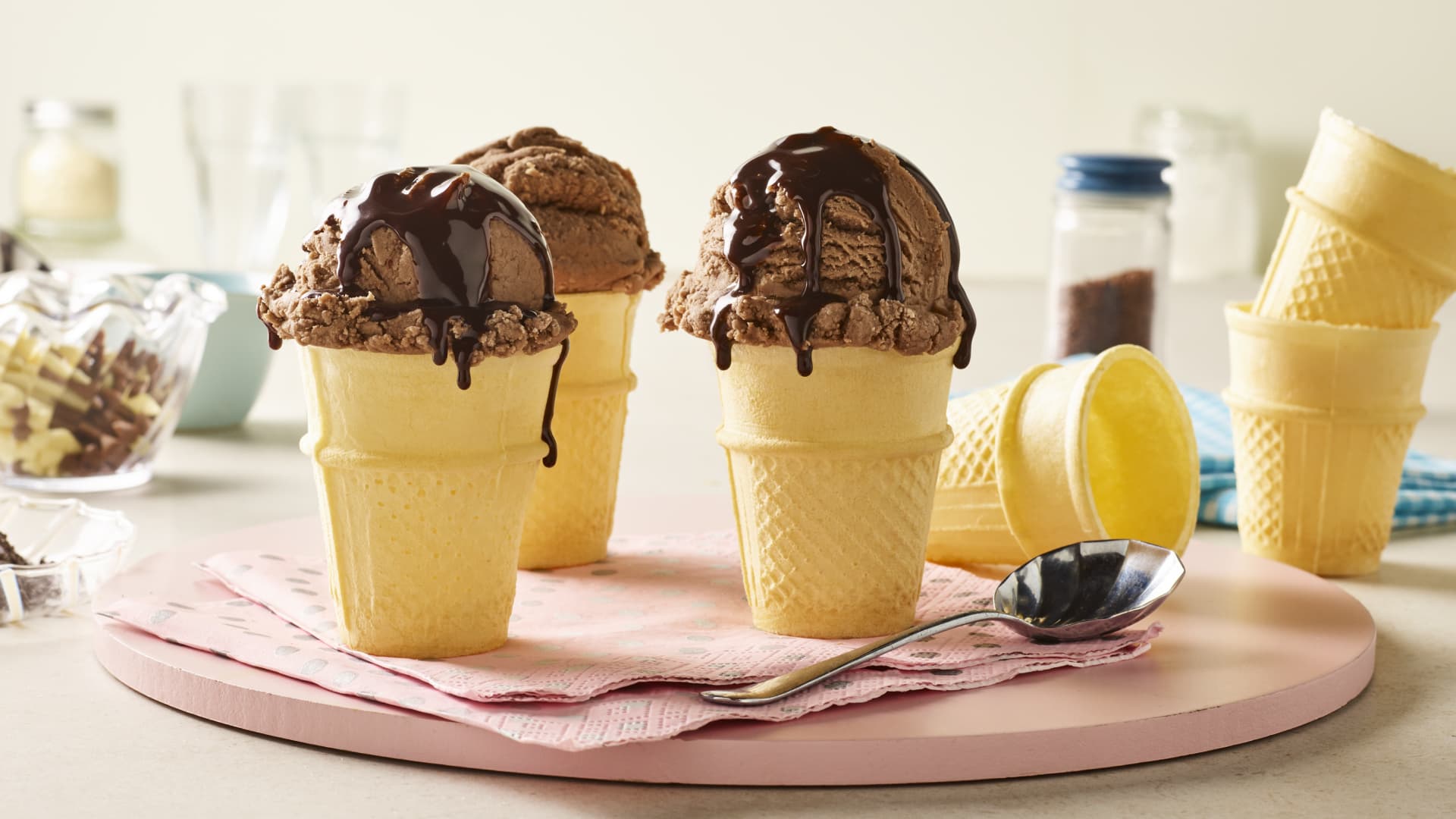 Wafer cones filled with chocolate ice cream and topped with chocolate sauce.